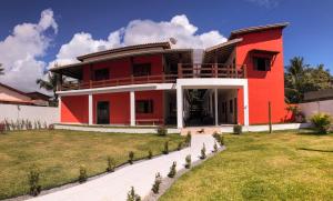 伊尔哈德博伊巴POUSADA TUPINAMBA的前面有草坪的红色房子