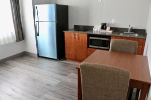 CalciumQuality Inn & Suites Watertown Fort Drum的厨房配有冰箱和桌椅