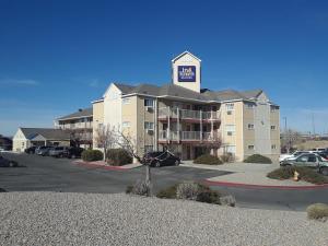 阿尔伯克基InTown Suites Extended Stay Albuquerque NM的一座大型公寓楼,上面有标志