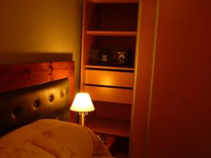 里奥夸尔托花园洋房饭店的一间卧室,配有一张床和书架旁边的一盏灯