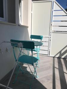 吉诺萨滨海IL CUCCO B&B的阳台上配有两张绿色椅子和一张桌子