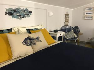 吉诺萨滨海IL CUCCO B&B的一间卧室配有黄色和白色枕头的床