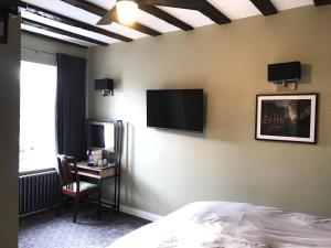 塞尔比Bay horse hotel的卧室配有一张床,墙上配有电视。