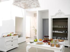 凯特利奥斯奥立佛梅尔酒店的白色的厨房,配有桌子和食物