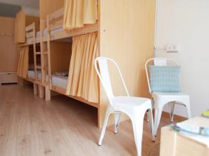 阿瓜尔达Albergue O Peirao的配有双层床的客房内配有2把椅子和1张书桌