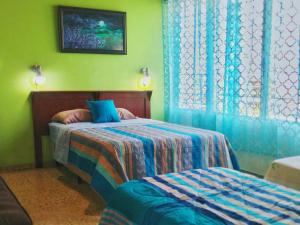 圣萨尔瓦多绿洲住宿加早餐旅馆的一间卧室设有两张床和窗户。