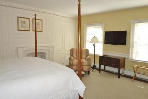 普林斯顿格伦凯恩酒店的一间卧室配有一张床、一把椅子和电视。
