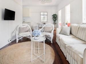 佩里吉安比奇Lake Weyba Noosa Lodge & Kangaroos的客厅配有白色的沙发和椅子