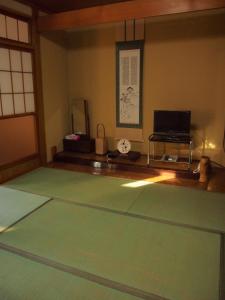 鹤冈市羽黒馆酒店的一间设有绿色地毯和桌子的房间