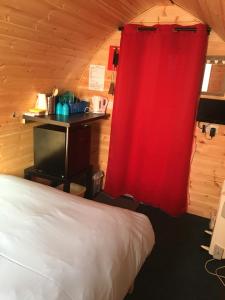 HullandPoplars Farm Site Glamping Pods的一间设有床铺和红色窗帘的房间