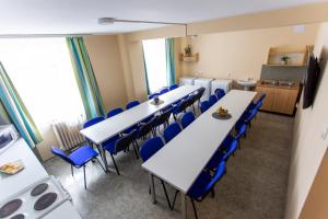 多瑙新城PD Hostel的一间会议室,配有白色的桌子和蓝色的椅子