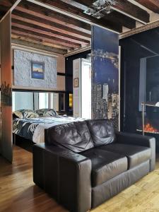 马德里Apartamento MADRID CENTRO GRAN VIA - CALLAO的一间卧室配有一张床和一张皮沙发