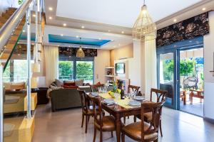 PangalochoriInn Villa, impeccable location, By ThinkVilla的用餐室以及带桌椅的起居室。