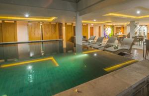 沙努尔马哈拉卡斯米精品酒店的一座配有桌椅的酒店游泳池