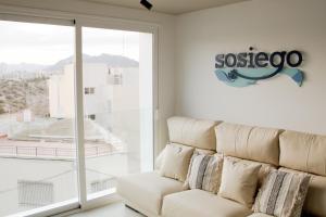 马萨龙港Sosiego Hostal de Mar的配有大窗户的客房内的白色沙发