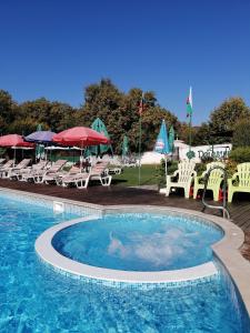 希萨里亚Detelina Complex的一个带椅子和遮阳伞的大型游泳池