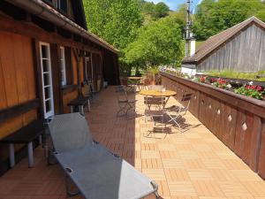 HofGasthaus Hirtenbrunnen的木制甲板上配有桌椅的庭院