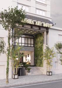 胡志明市Adora Art Hotel的前面树木的艺术酒店的入口