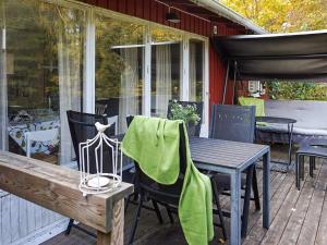 Norra Svärdsö6 person holiday home in SORUNDA的露台设有桌椅