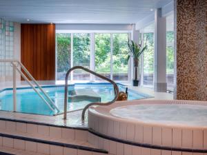 蒙斯特Hotel Restaurant & Spa Verte Vallée的一个带游泳池的酒店客房内的热水浴池