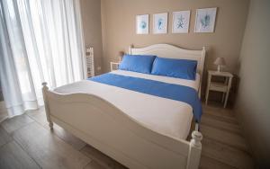 特拉尼Torrelama Room & Breakfast的卧室内的白色床和蓝色枕头