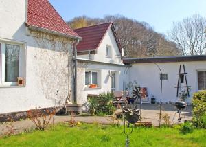 朱列斯拉赫Ferienwohnung Breege RUeG 1951的白色的房子,有红色的屋顶和院子