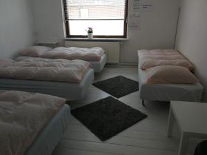 KolindPasescia Bed and Breakfast.的一间设有四张床、一个窗口和一张桌子的房间