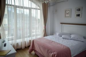 MăneciuHotel Coquette的一间卧室设有一张床和一个大窗户