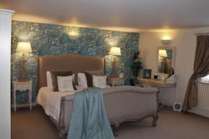 贝尔顿The Queens Head的一间卧室配有一张蓝色花卉壁纸床