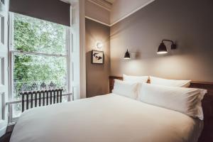伦敦朝圣者酒店的卧室设有一张白色大床和一扇窗户。
