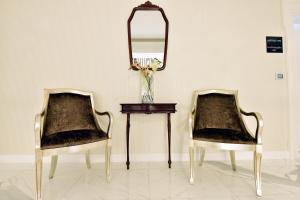 波德戈里察子牙酒店的两张椅子坐在一张桌子旁,配有镜子