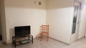 布拉芒Gites de la combe的客厅配有电视和椅子