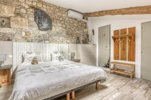 蓬乔利塞布尔住宿加早餐旅馆的一间卧室设有一张大床和石墙