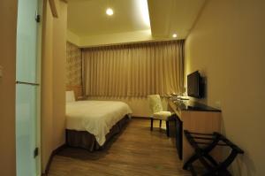 花莲市花莲福品旅店的酒店客房配有一张床、一张书桌和一台电视。