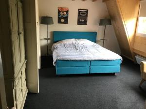 东卡佩勒Sonop的一间卧室配有一张蓝色的床和两盏灯。