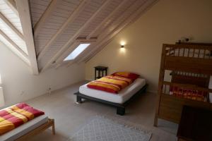 NesslauZwinglis Ferienwohnung的阁楼卧室设有两张床和梯子