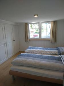 NesslauZwinglis Ferienwohnung Klärli的卧室设有两张床,带两个窗户