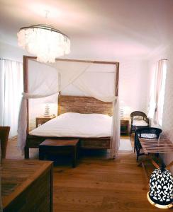克尔克普拉卡精品酒店的一间卧室配有一张天蓬床和吊灯。