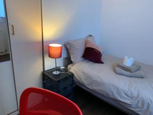 伦敦The Heart Of Stratford..!的一间卧室配有一张带灯和椅子的床