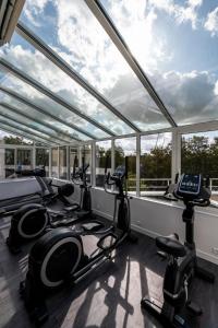 兰斯钟楼雷姆中央大教堂酒店的一个带跑步机和椭圆机的健身房,位于带窗户的房间内
