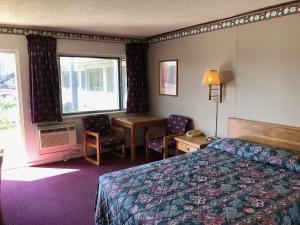 萨利纳埃姆巴西汽车旅馆的配有一张床、一张书桌和一扇窗户的酒店客房