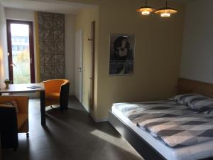 德绍Appartements am Bauhaus的一间卧室配有一张床、一张书桌和一个窗户。