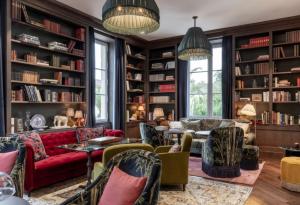 圣埃斯泰夫La Maison d'Estournel的客厅配有书架和红色沙发
