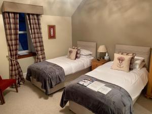 因弗内斯Drumdale Bed and Breakfast的一间卧室设有两张床和窗户。