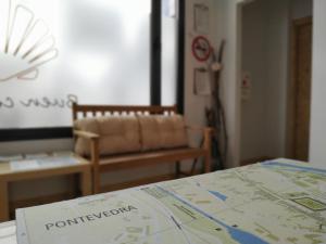 庞特维德拉Albergue Nacama Hostel Pontevedra PEREGRINOS PILGRIMS的一张桌子上的地图,一张沙发放在一个房间里