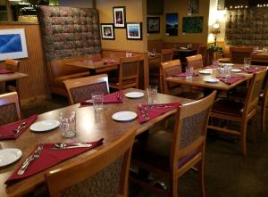 索尔多特纳Soldotna Inn的餐厅设有木桌和红色餐巾