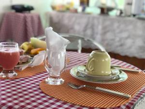 Barra do CamaragibePousada Tiriri Guesthouse的餐桌,饭盘和饮料