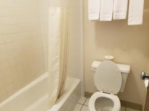 科罗拉多斯普林斯旅行之星套房酒店的浴室设有卫生间和带淋浴帘的浴缸。