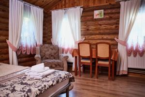 切尔尼戈夫Zolotoy Bereg Hotel的卧室配有一张床和一张桌子及椅子
