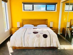 阿波罗湾Apollo Bay Seal Apartments的一间卧室设有一张黄色墙壁的大床